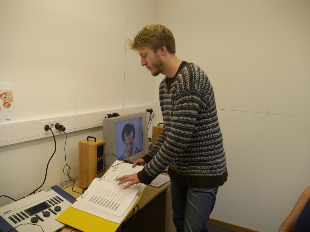 Audiolog Rolf Mjønes står framför en dator-
