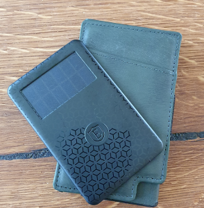 En grån plånbok med ett lite tjockare svart smart kort med soceller ovanpå
