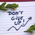 foto: Handskriven text ”don't give up" och två kvistar med gröna blad.